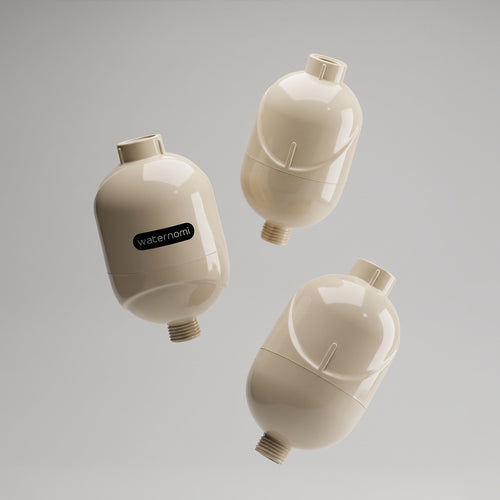 Three Waternomi shower filters floating in soft pearl beige